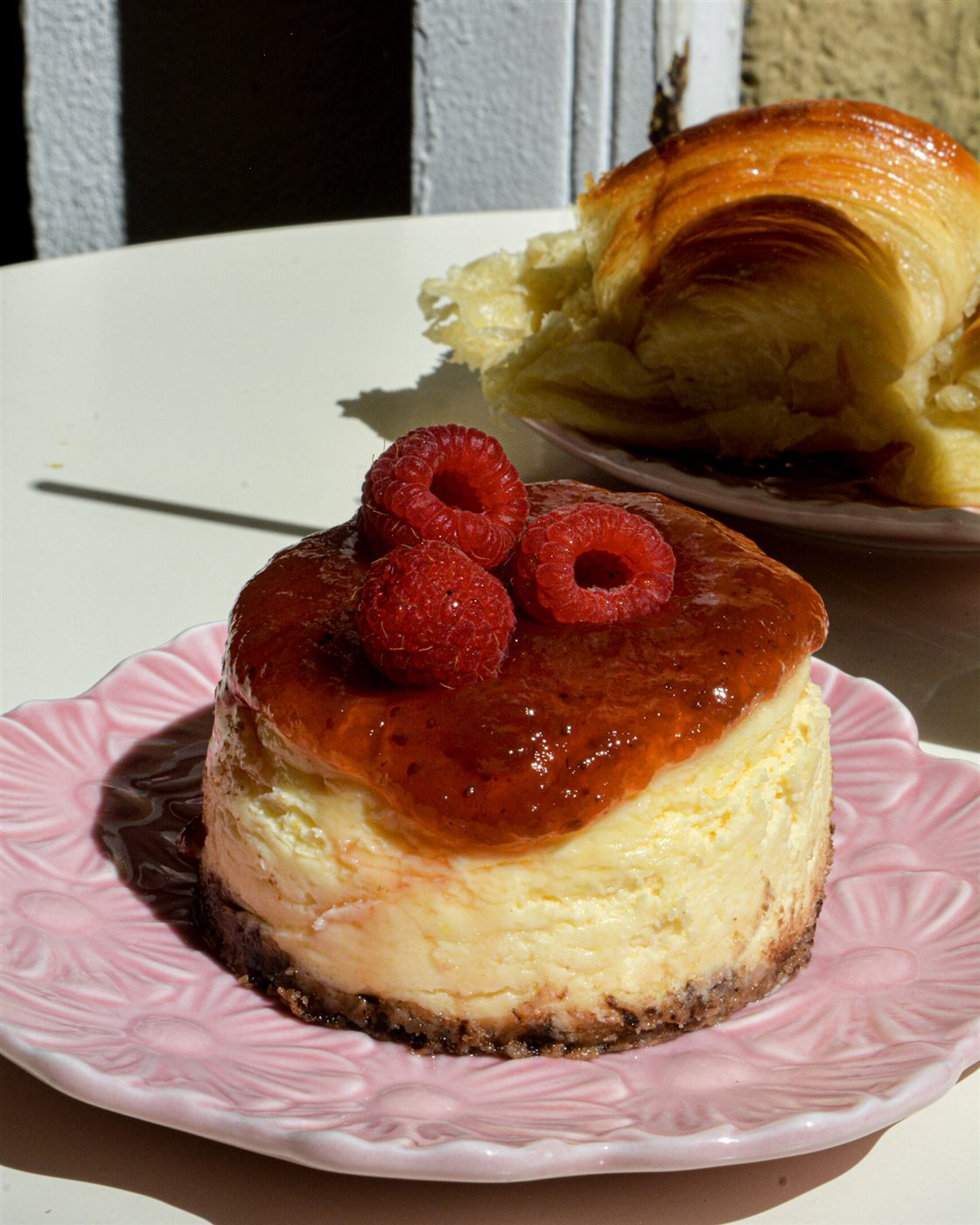 Cheesecake con frambuesas en vajilla rosa