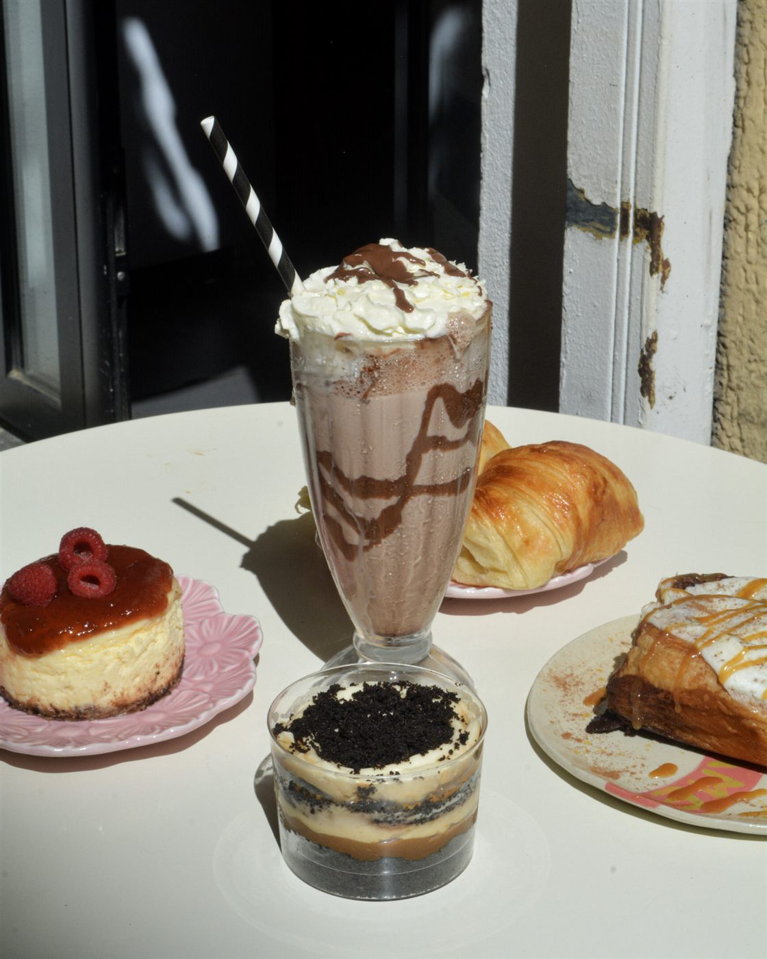 Selección de bebidas y pastelería en una mesa al sol