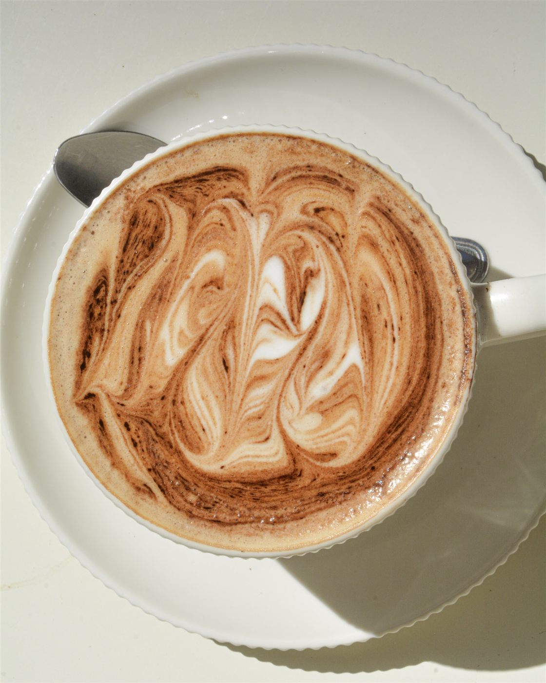 Detalle de arte latte en taza blanca